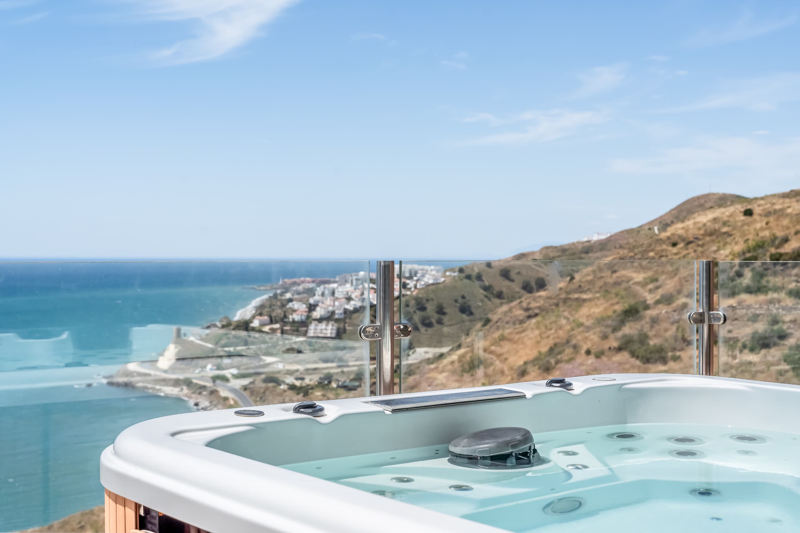Piscina infinita en azotea con jacuzzi al atardecer, sobre el Mediterráneo